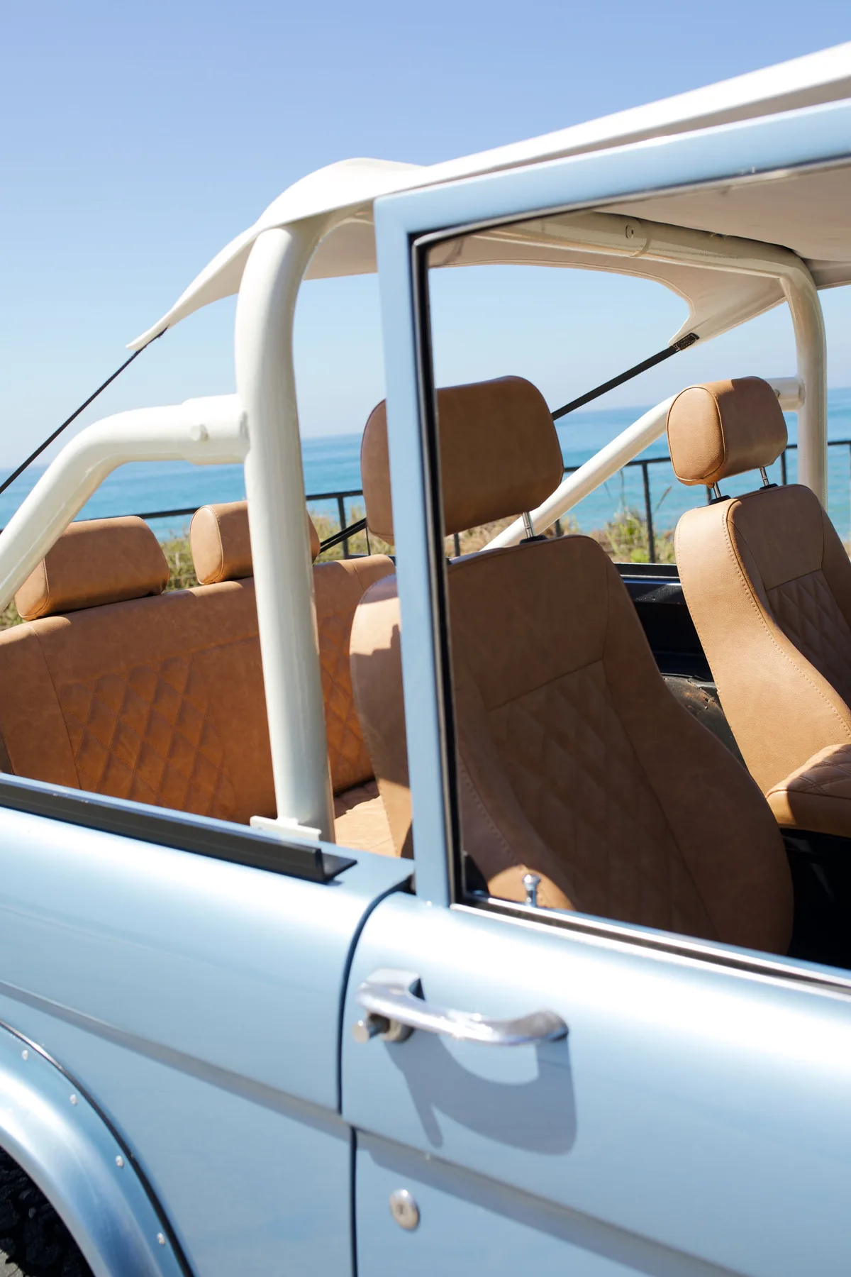 Open-top Bronco interior with white cage and tan leather
